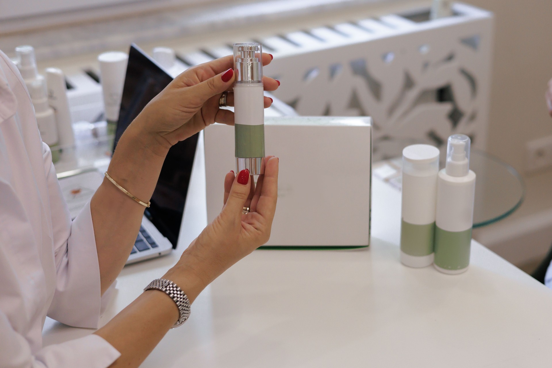 Doctor cosmetologist holds a cosmetic bottle